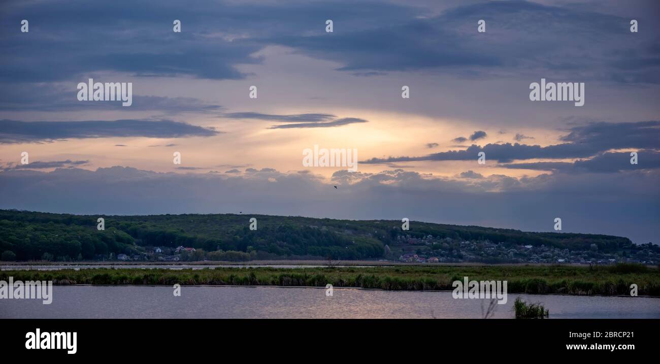 Evening landscape with lake, reeds and dramatic sky Stock Photo