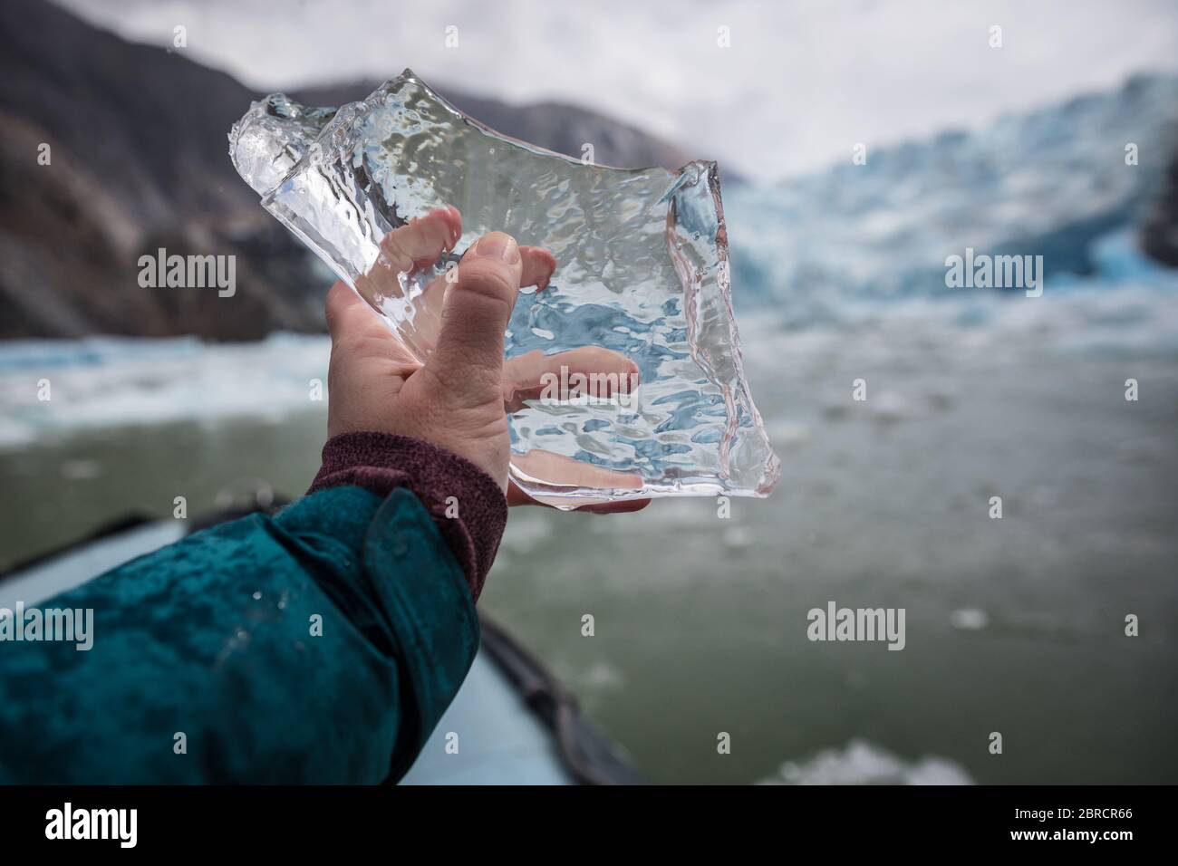 icebergs calved from South Sawyer Glacier float down Tracy Arm Fjord, Southeast Alaska, USA, past adventurous tourists on skiff boats from a cruise Stock Photo