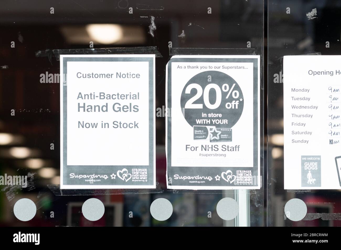 Superdrug store during coronavirus pandemic with signs advertising anti-bacterial hand gels now in stock and 20% discount for nhs staff - Glasgow Stock Photo