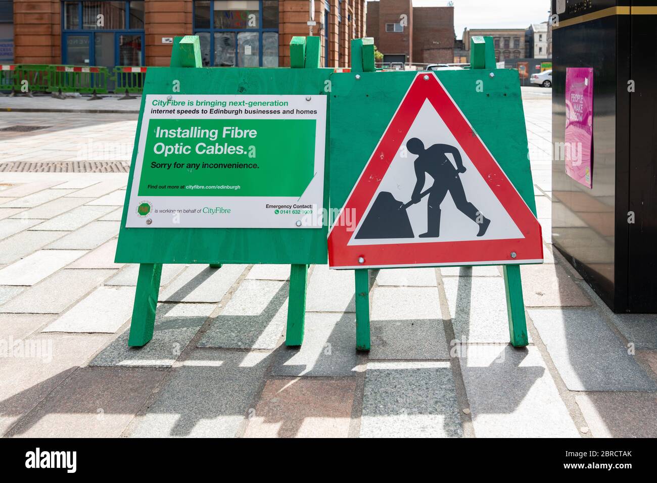 Installing Fibre Optic Cables road signs by city-fibre (mistakenly says Edinburgh on sign) - Glasgow, Scotland, UK Stock Photo