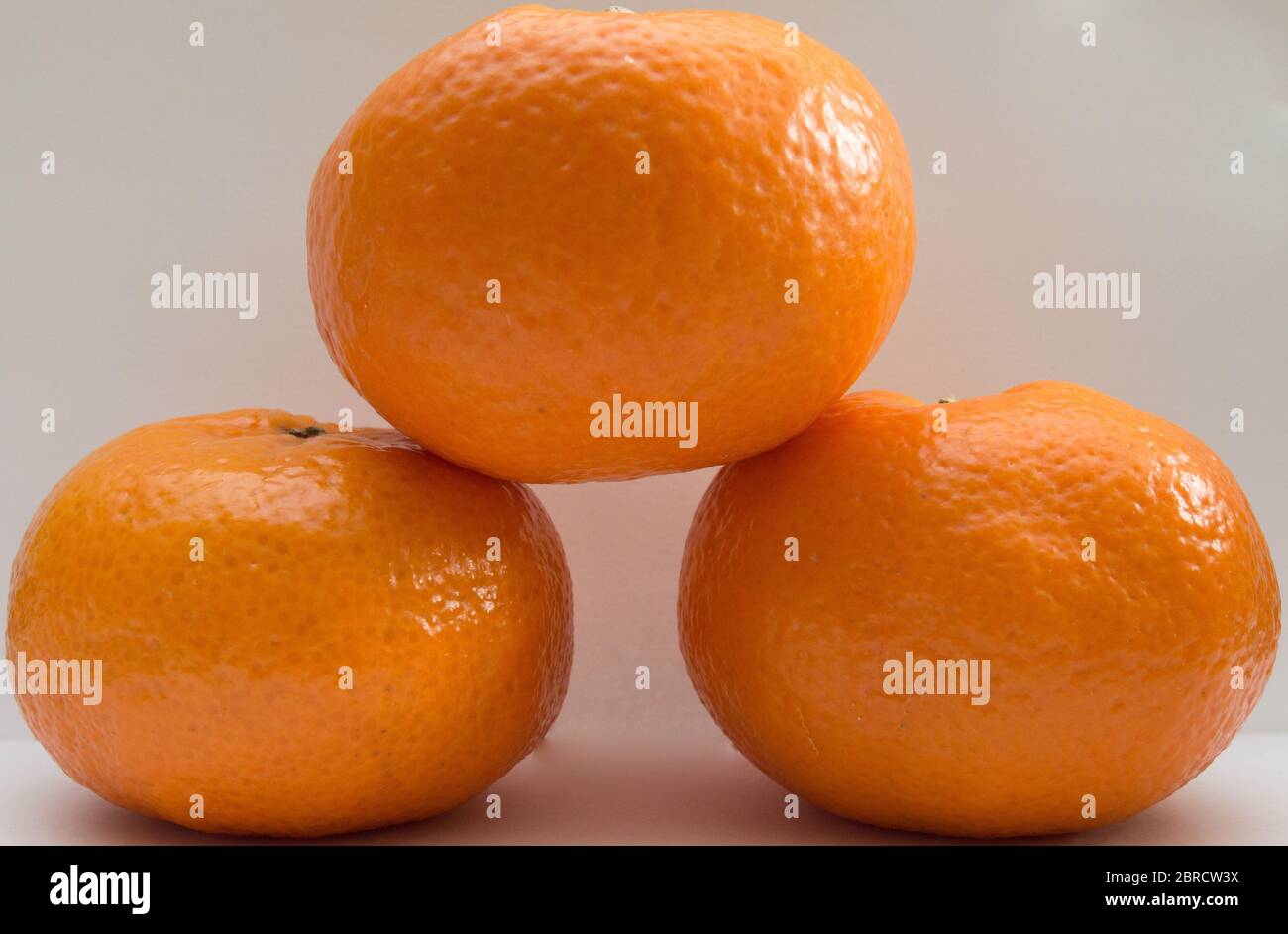 Three Tangerines Podium On White Background Stock Photo