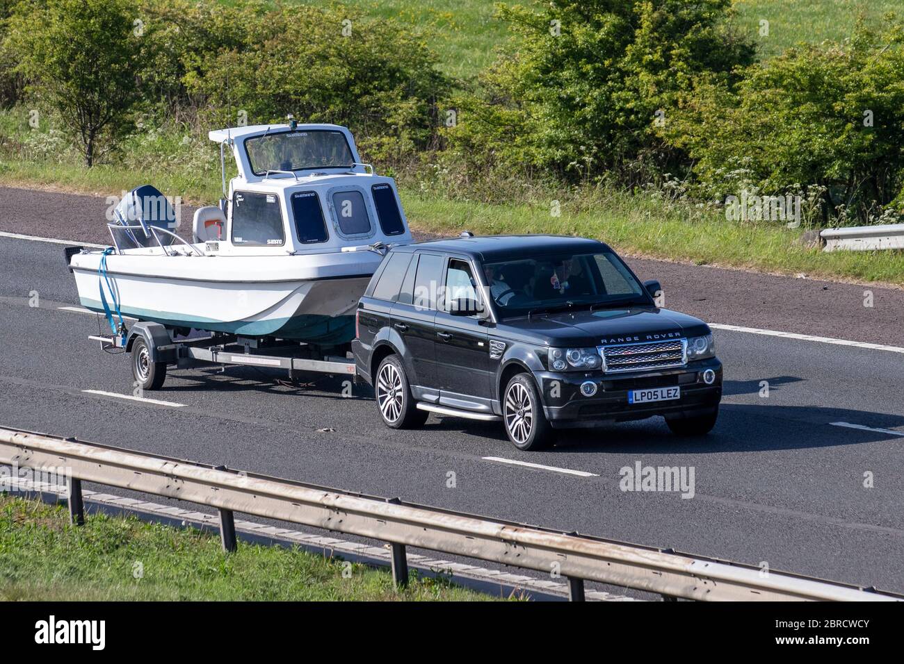 2007 black Land Rover Range Rover SP HSE TDV8 A towing boat trailer; Vehicular traffic moving vehicles, cars driving vehicle on UK roads, motors, motoring on the M6 motorway highway Stock Photo