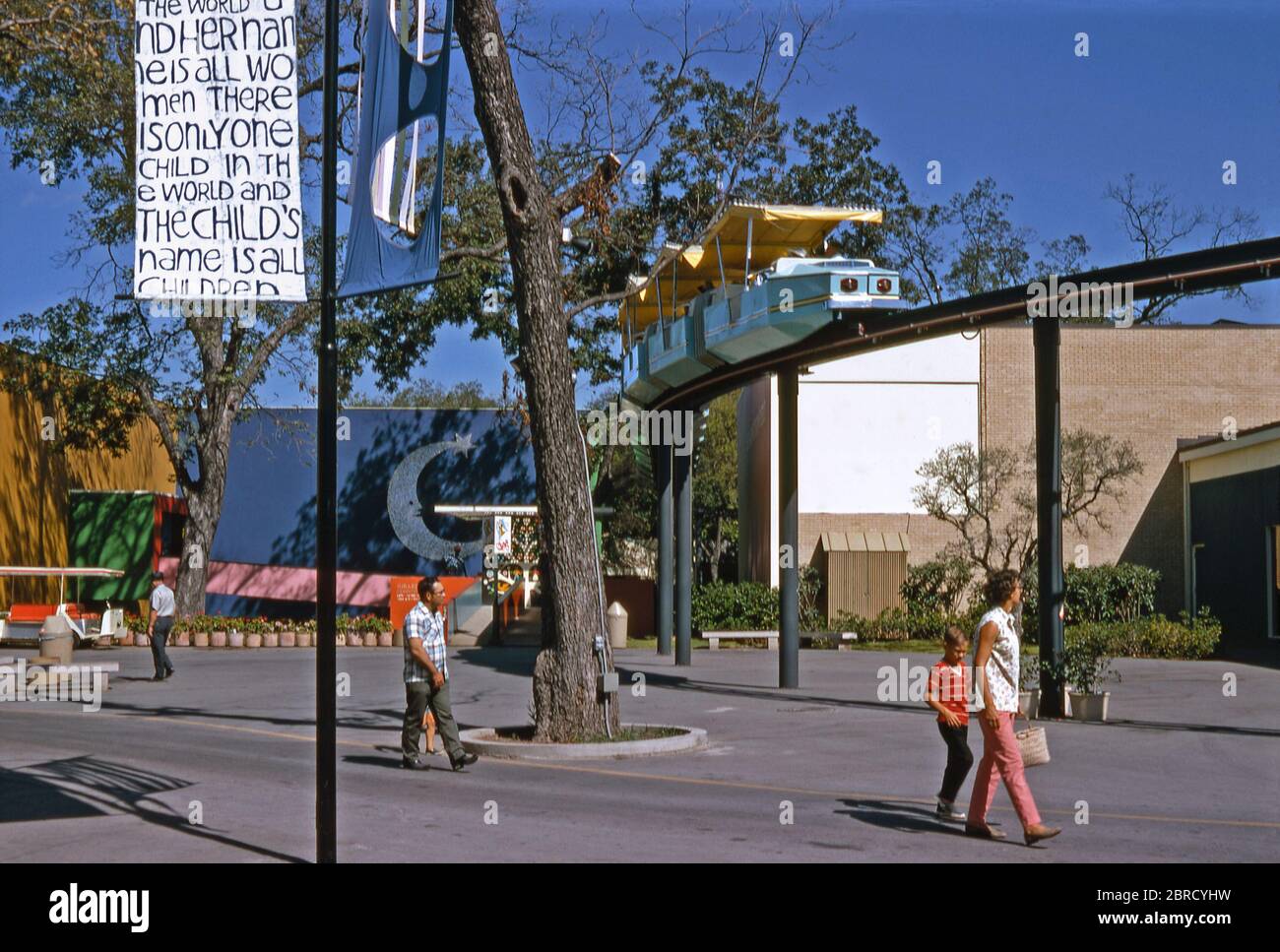 Visitors to 'HemisFair '68', an official World's Fair (Expo or International Exposition) held in San Antonio, Texas, USA in 1968. A 'Mini-Monorail' train passes overhead. Stock Photo