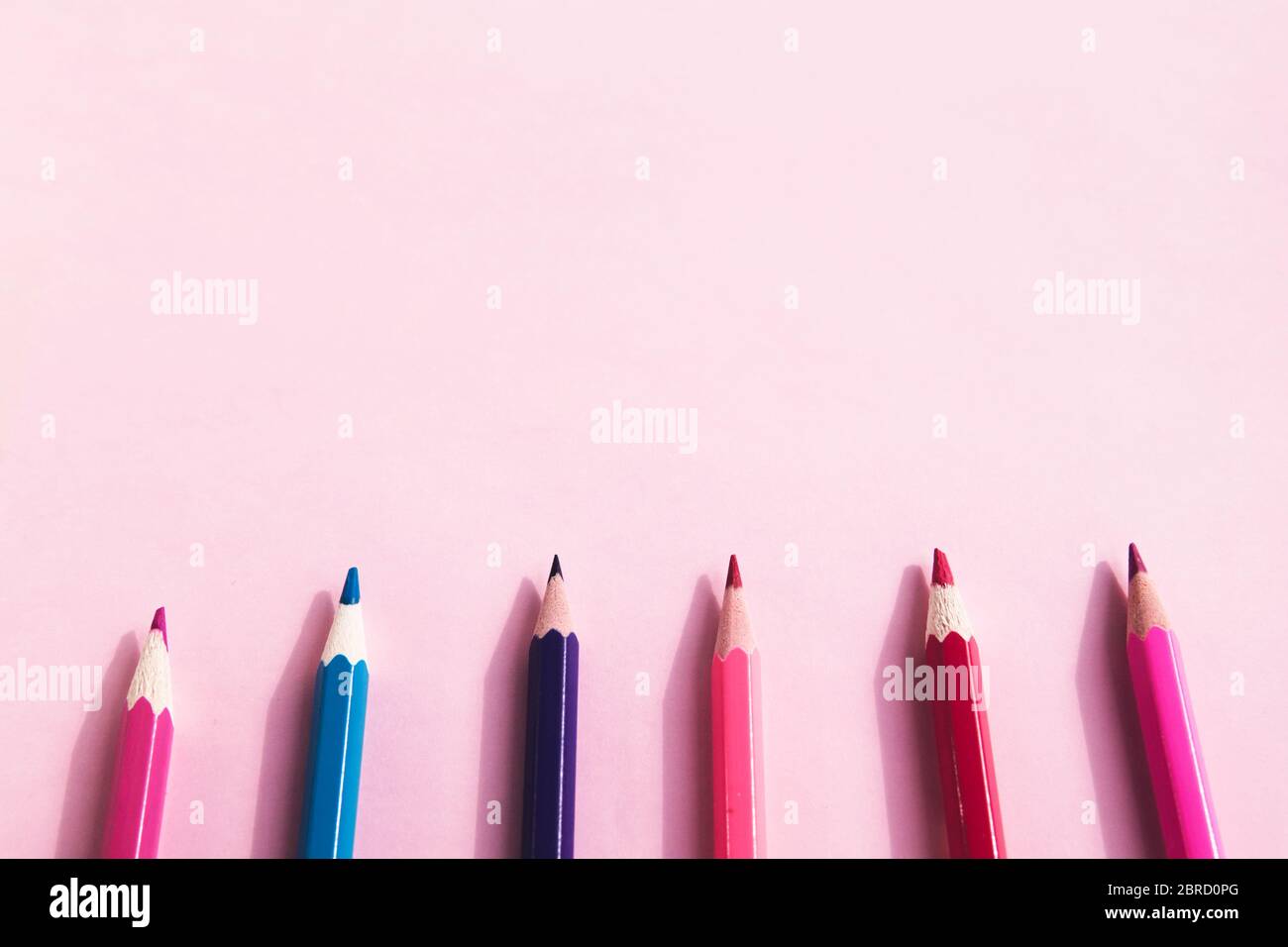 Background of colorful pencils on pink background. Back to school, education and learning concept. Minimalist isometric concept. Stock Photo