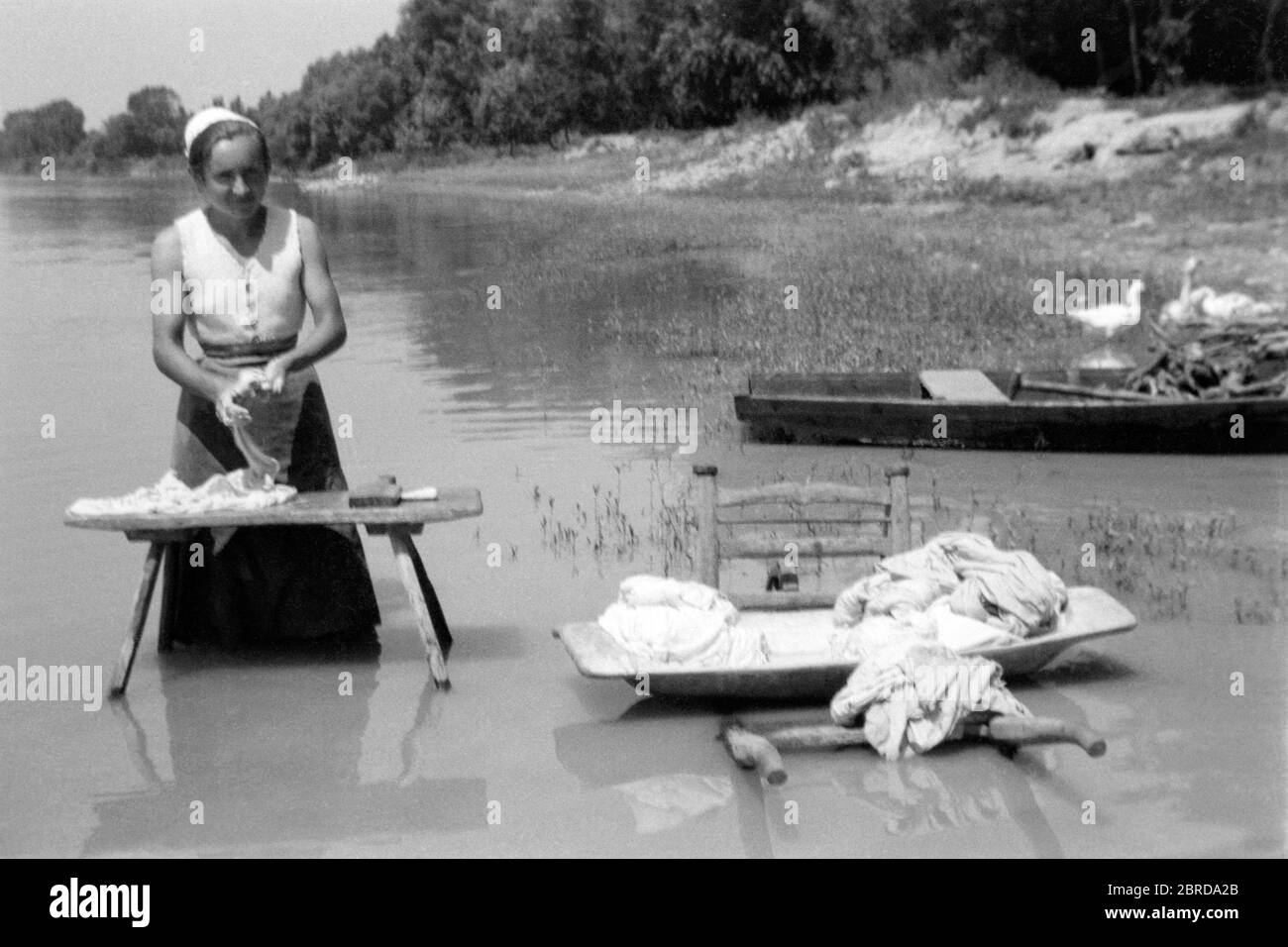 https://c8.alamy.com/comp/2BRDA2B/woman-doing-laundry-by-hand-washing-clothes-in-river-1940s-hungary-2BRDA2B.jpg