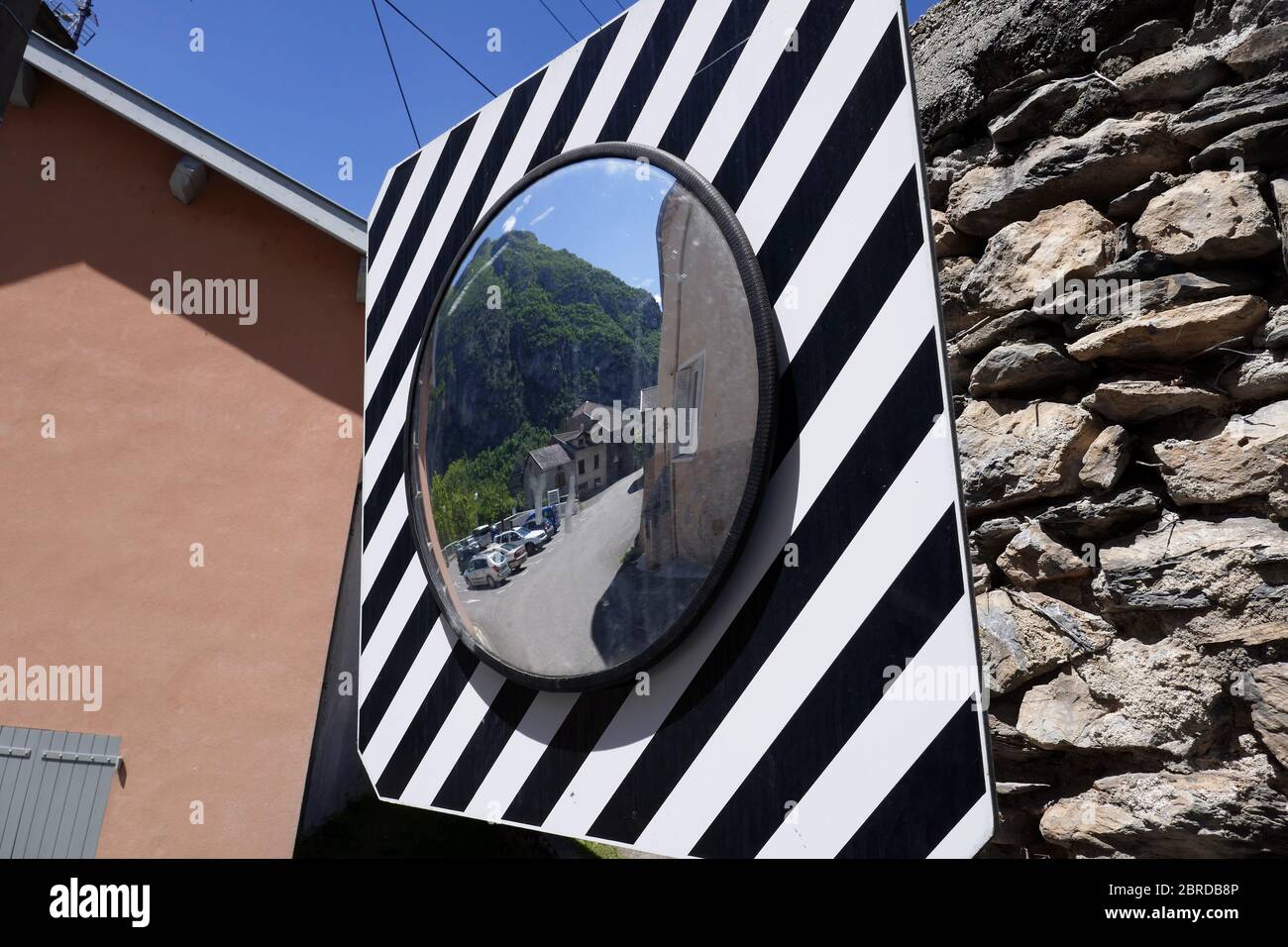 Mirror for seeing traffic around a bend, Ornolac Ussat les Bains, Ariege, French Pyrenees, France Stock Photo