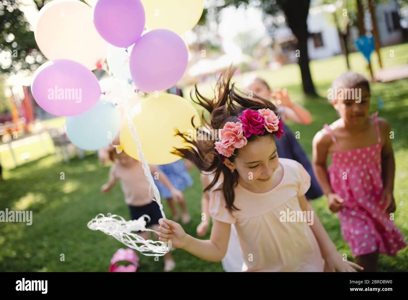 Small children running outdoors in garden in summer, playing. Stock Photo