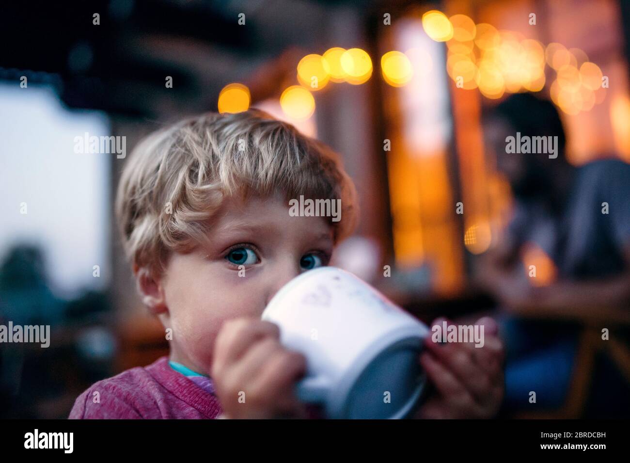 https://c8.alamy.com/comp/2BRDCBH/close-up-of-toddler-boy-standing-outdoors-drinking-from-cup-2BRDCBH.jpg