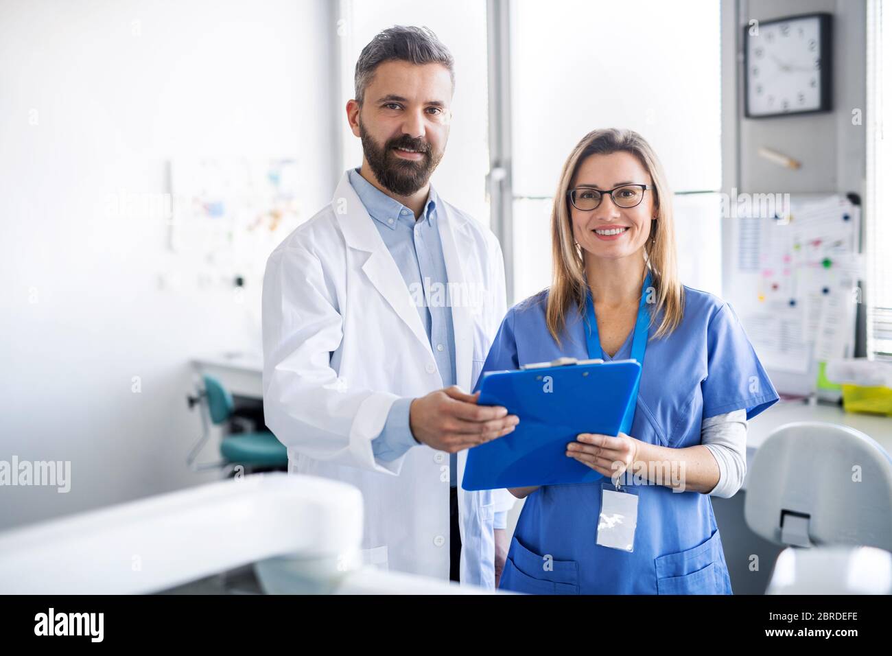 A dentist with dental assistant in modern dental surgery Stock Photo ...