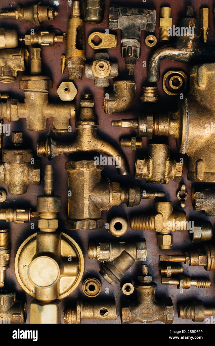 https://c8.alamy.com/comp/2BRDFRP/brass-scrap-metal-taps-tees-plugs-and-various-plumbing-parts-spare-parts-against-the-background-of-a-copper-sheet-close-up-2BRDFRP.jpg