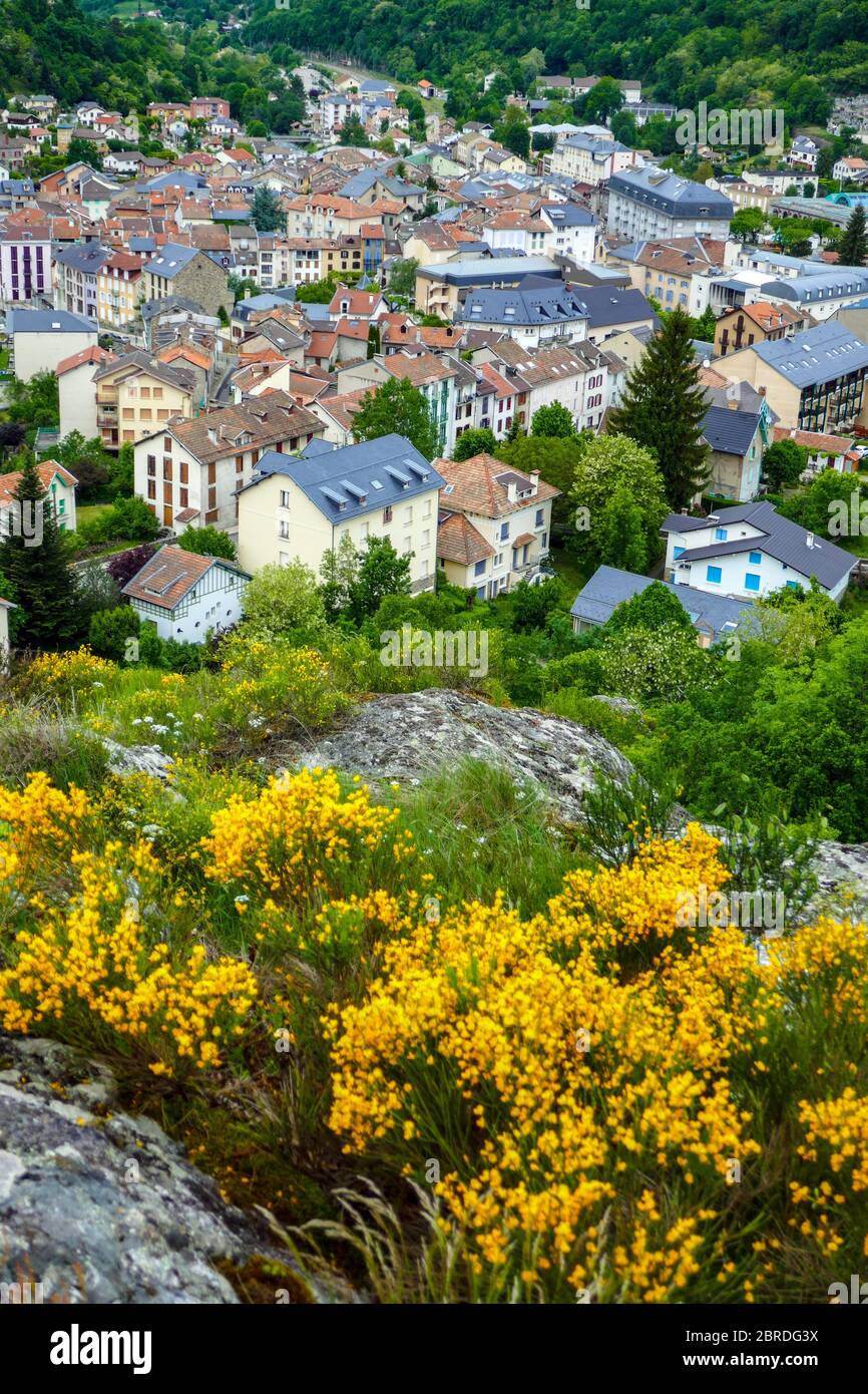 The spa town of Ax-les-Thermes with yellow flowers in the French Pyrenees Mountains Stock Photo
