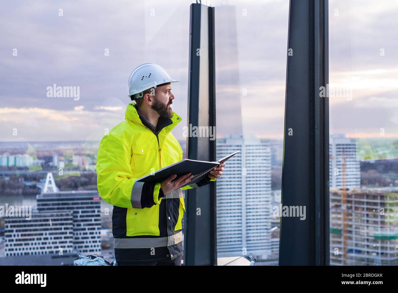 Man engineer standing on construction site, holding blueprints Stock ...