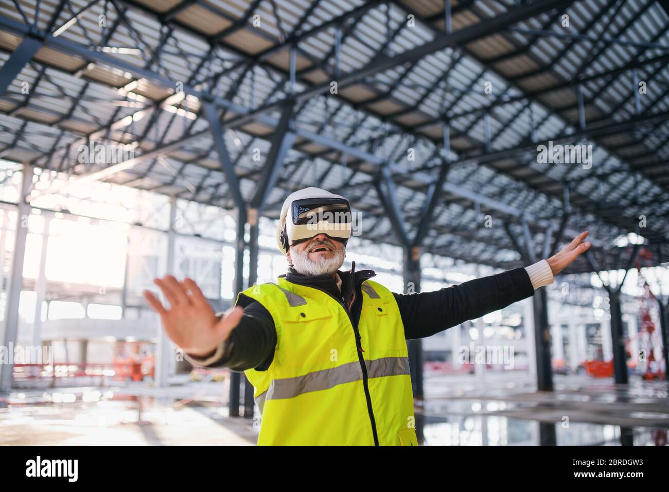 Man engineer using VR goggles on construction site. Stock Photo