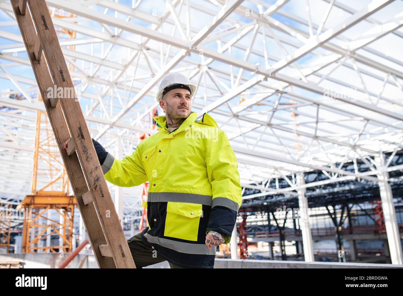 A man worker outdoors on construction site, working Stock Photo Alamy