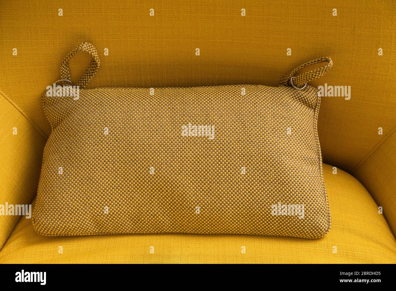 Decorative pillow on yellow textile sofa background. Home. Stock Photo