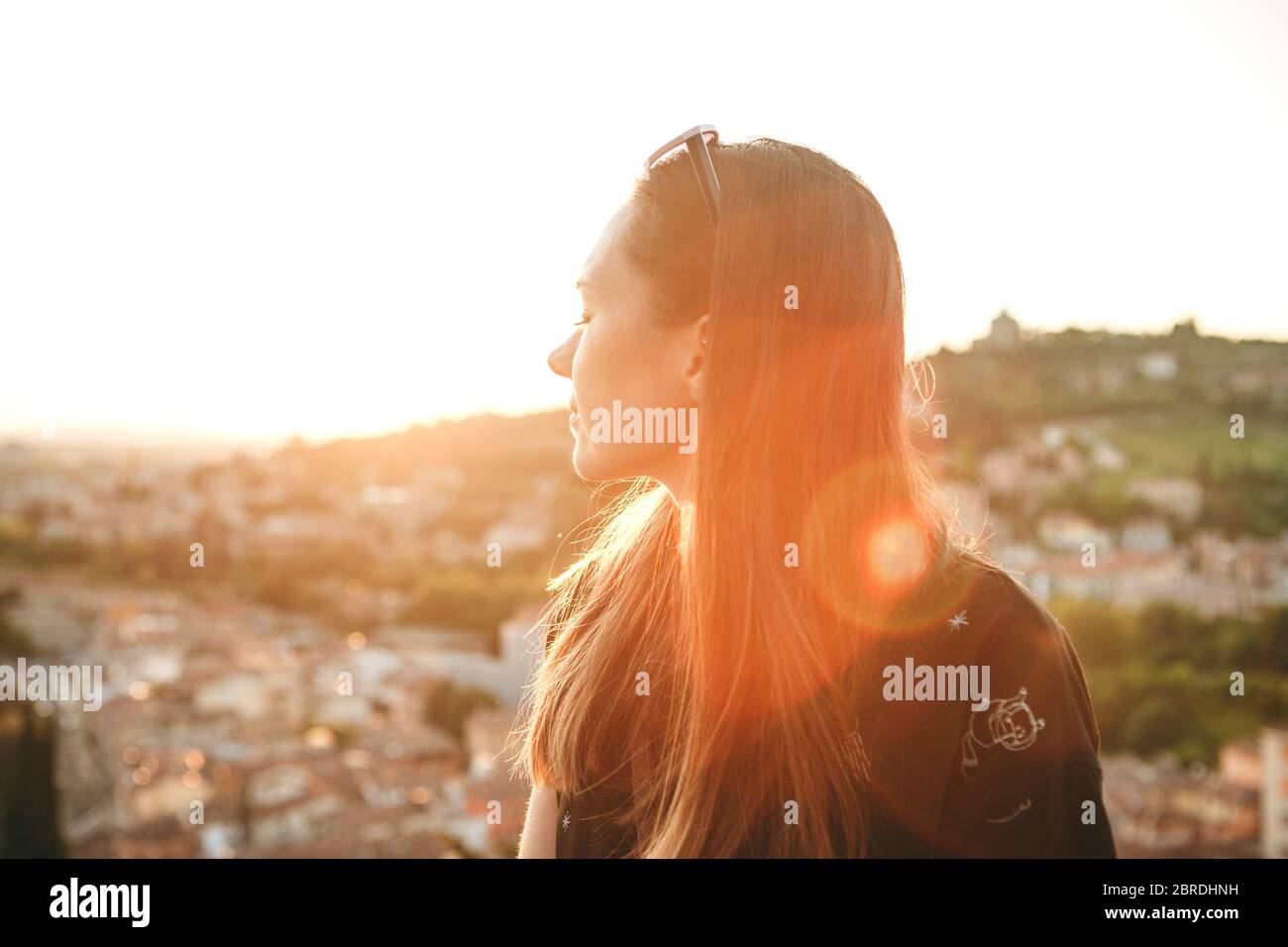Portrait of a beautiful young girl enjoying sunset with her eyes closed ...