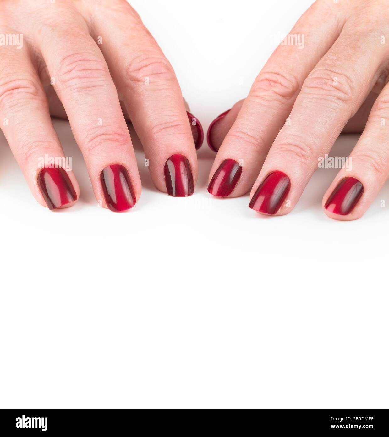Middle age womans hands with false red nails Stock Photo