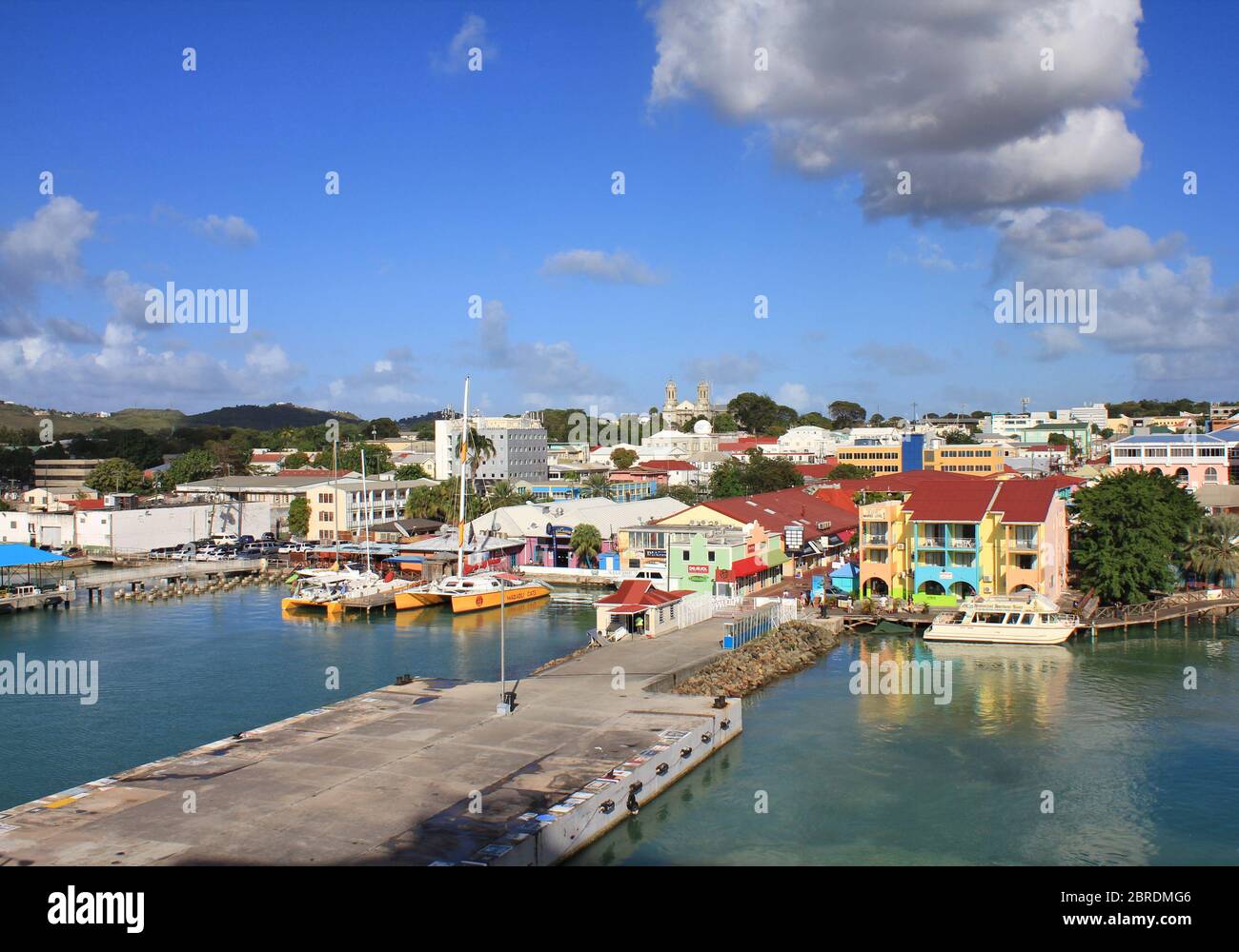 SAINT JOHN'S, ANTIGUA - FEBRUARY 19, 2014: Waterfront with pier and colorful houses in St John's, Antigua and Barbuda. Antigua is a popular destinatio Stock Photo