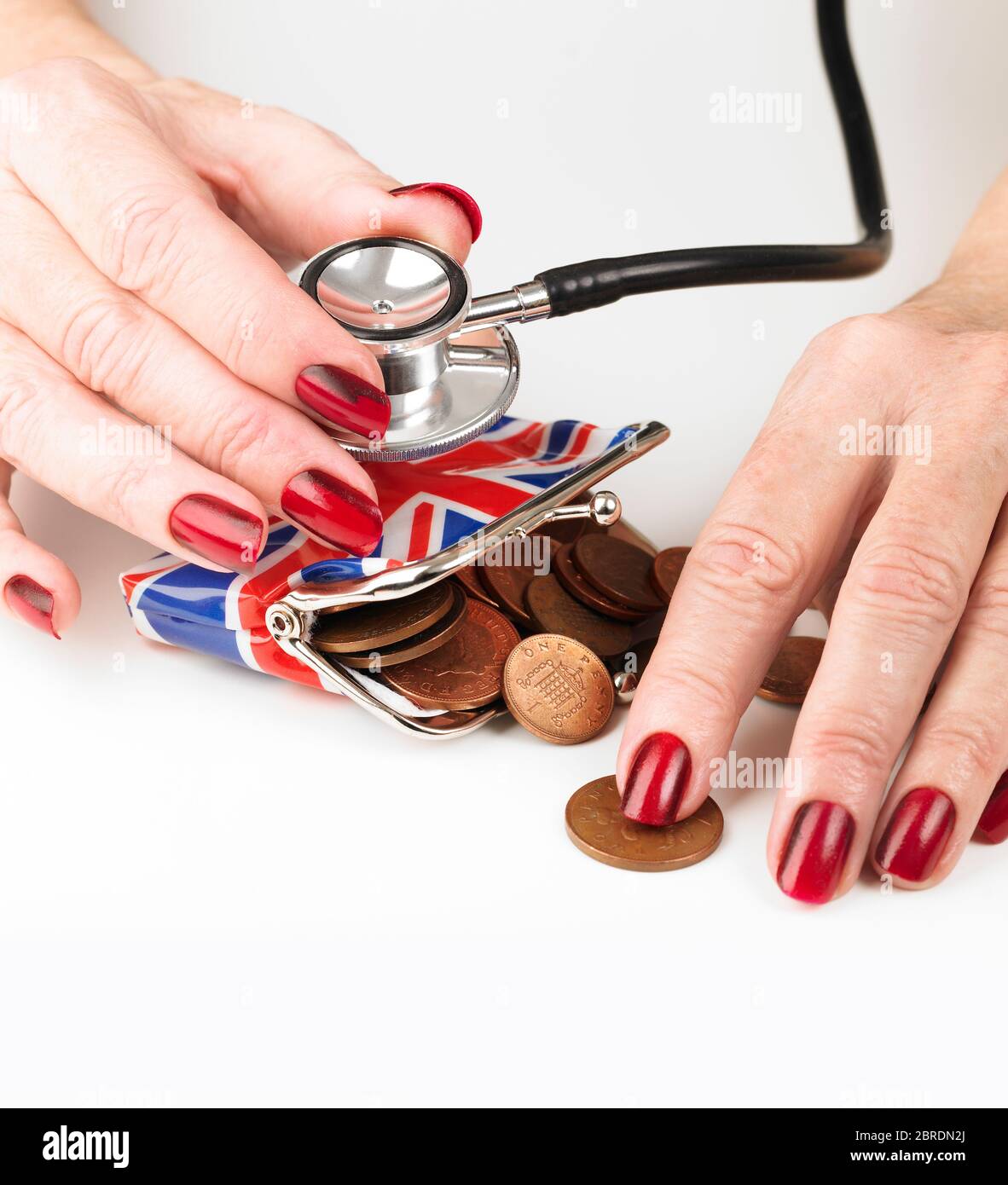 Hand holding a Stethoscope sounding a Union Jack purse Stock Photo