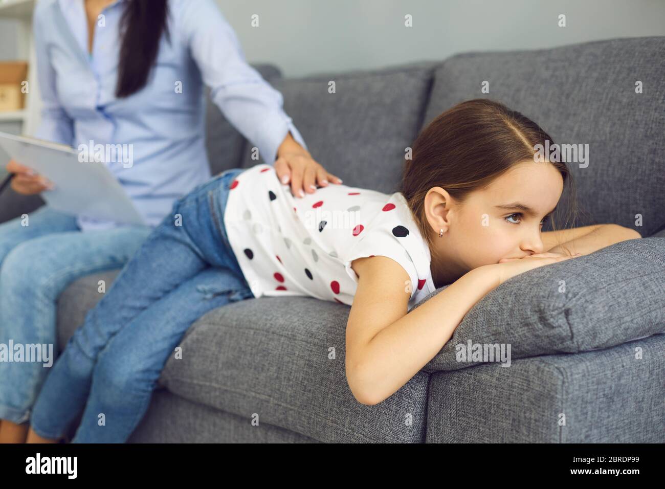 Child psychologist psychology. Woman psychologist with a clipboard helps a child with a problem in the room. Doctor psychologist reassures the patient Stock Photo