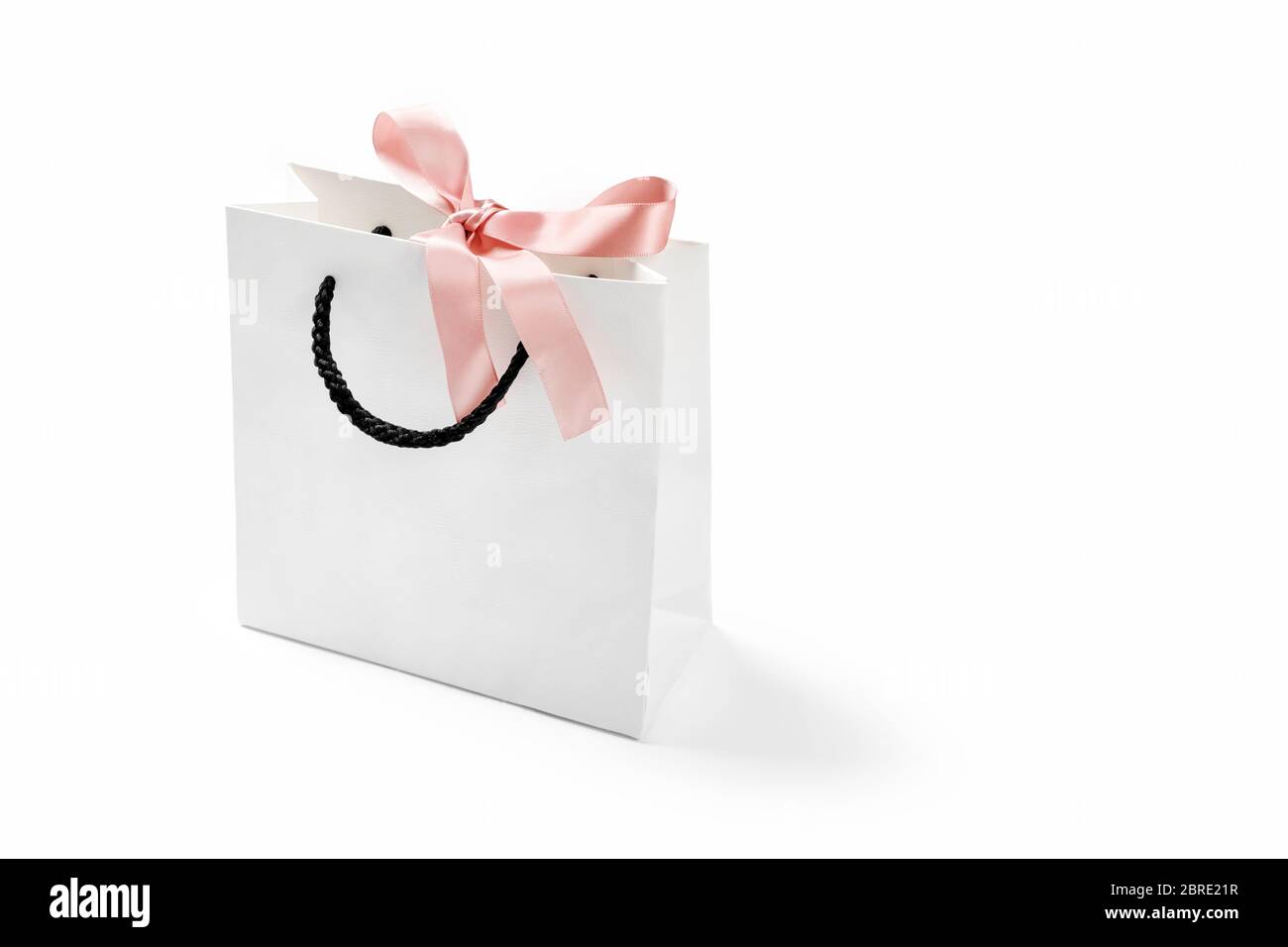 Mock-up of blank craft shopping package, mockup of white paper shopping bag  with handles and pink bow on the neutral background. Gift for holiday Stock  Photo - Alamy