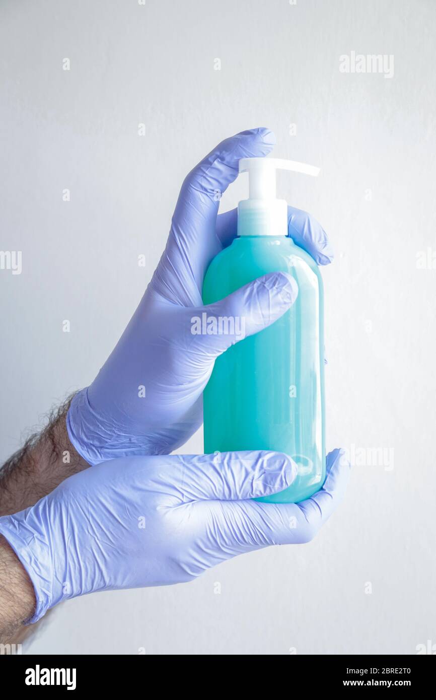 Hand wearing gloves and liquid soap to protect ourselves from covid19