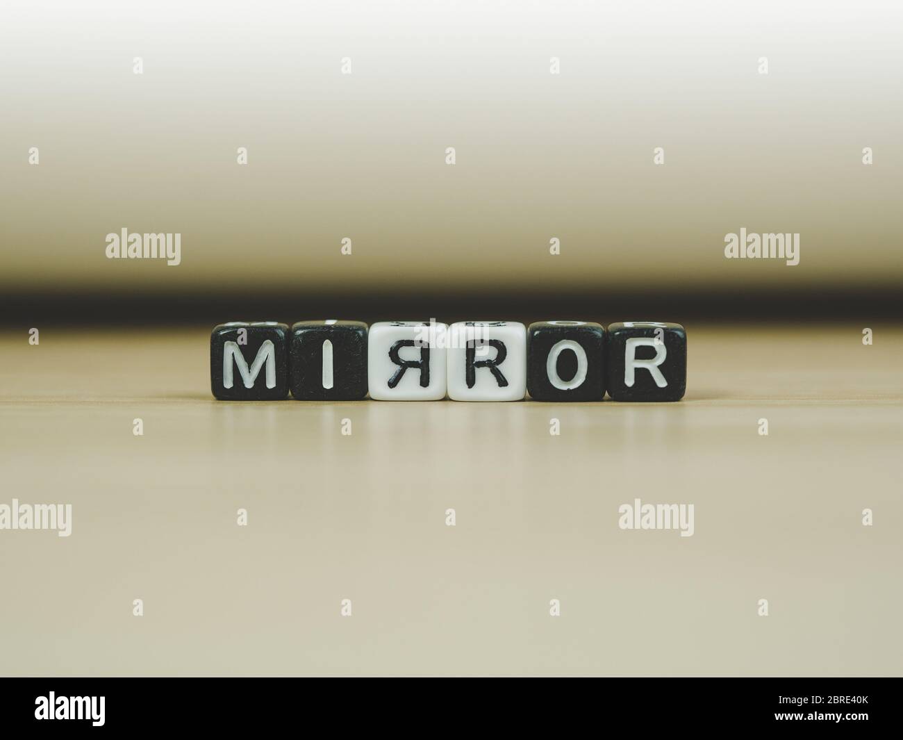 MIRROR word written in  cube on wooden floor on white background, letter blocks arranges into MIRROR words, for adding text or other images or design Stock Photo
