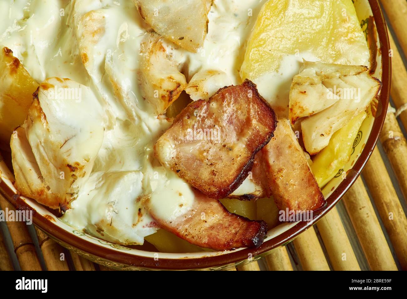 Smoked haddock savoy cabbage,bacon and creamy potato gratin Stock Photo Alamy