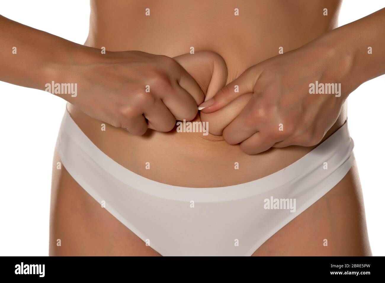 woman squeezing her belly fat on white background Stock Photo