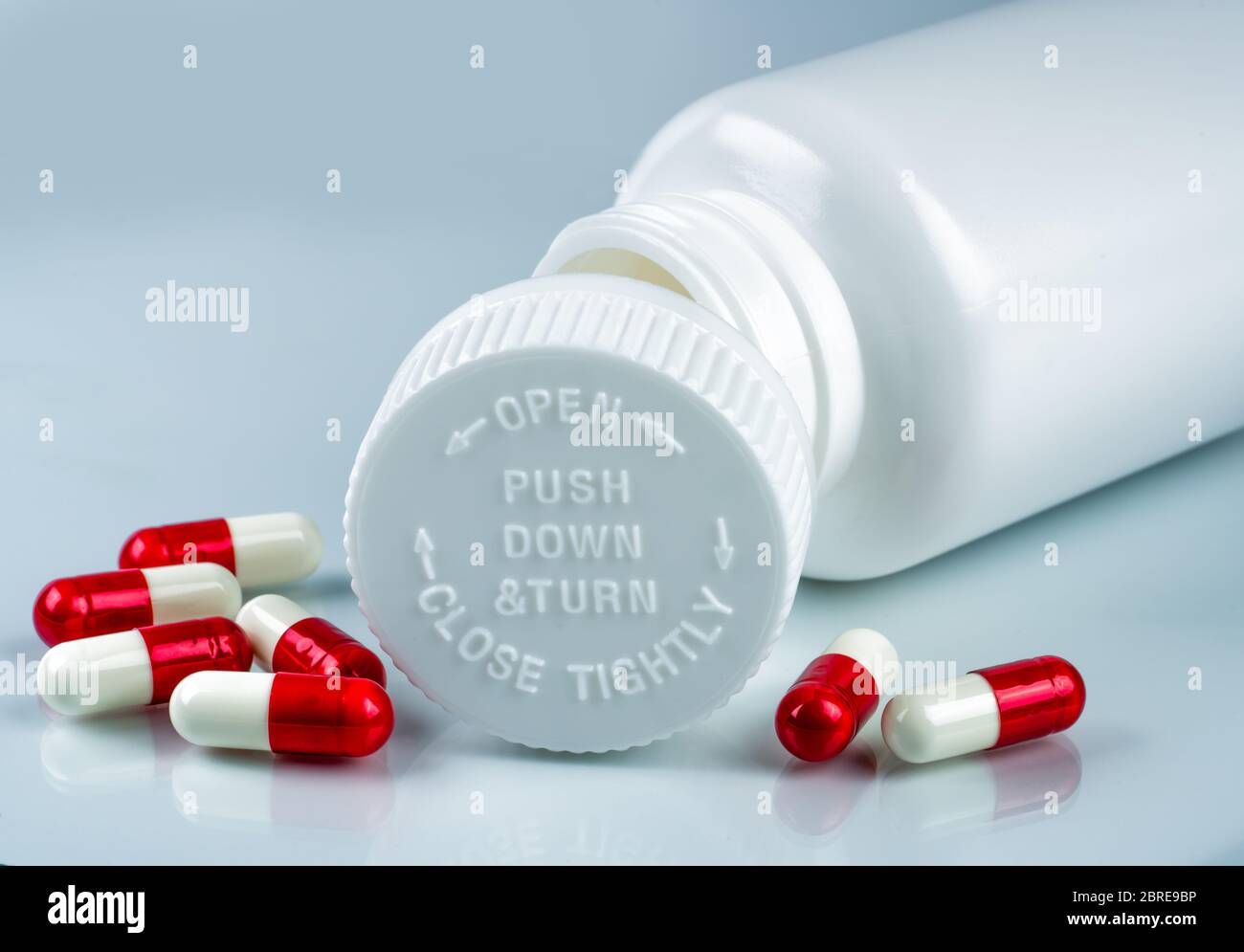 https://c8.alamy.com/comp/2BRE9BP/capsules-pills-on-white-background-and-plastic-bottle-with-blank-label-and-copy-space-childproof-packaging-child-resistant-pill-container-push-down-2BRE9BP.jpg