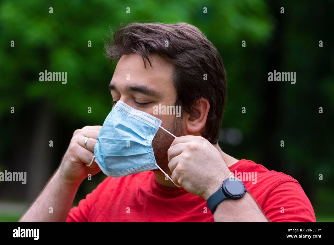 Man wearing surgical mask while he is outside Stock Photo - Alamy