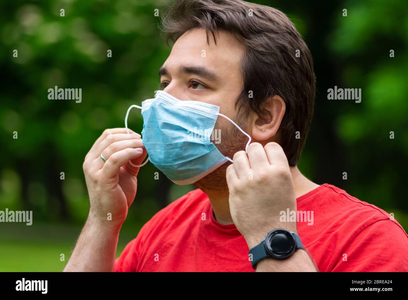 Man wearing surgical mask while he is outside Stock Photo - Alamy