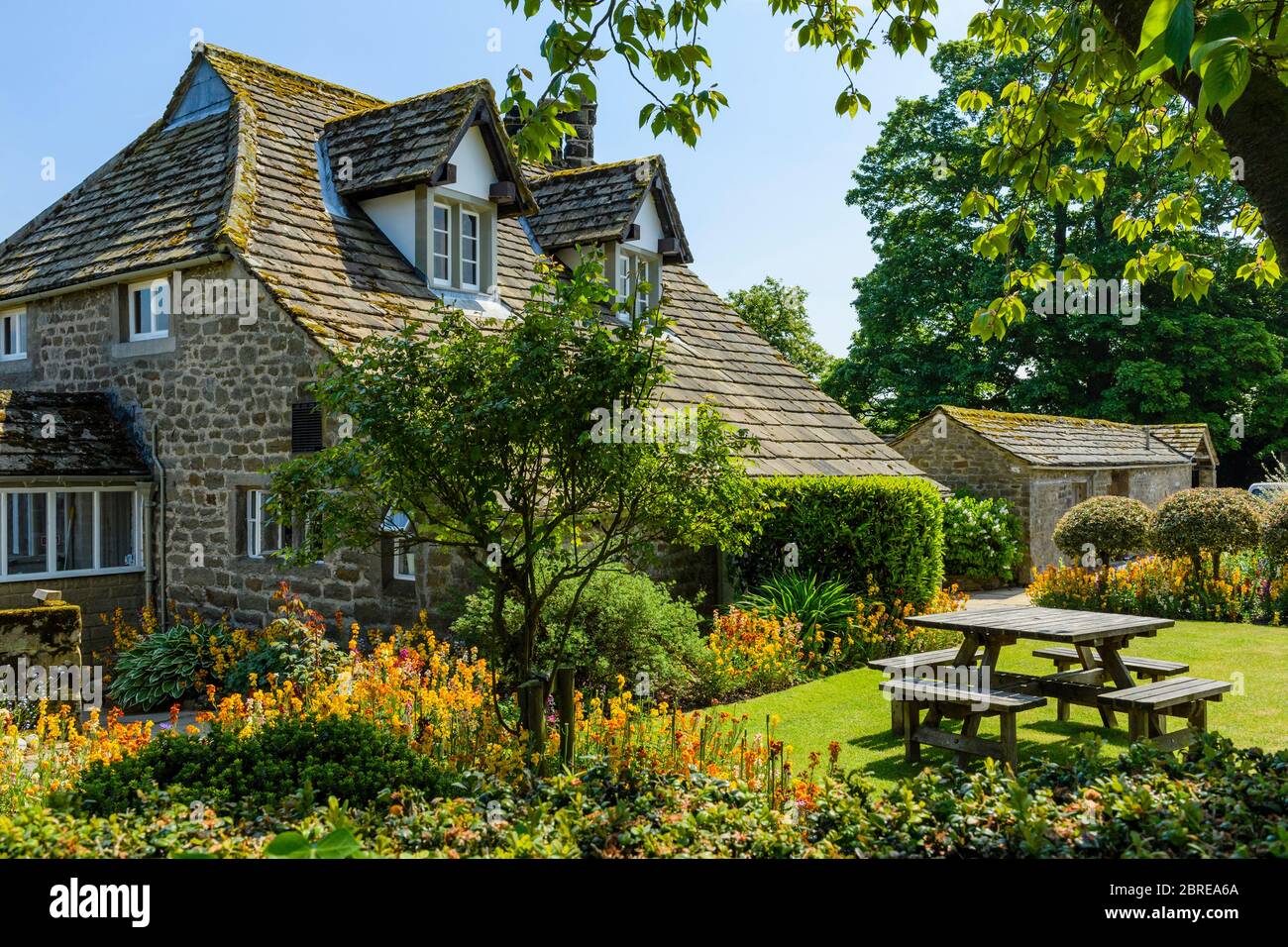 Exterior of quaint attractive cottage tea rooms cafe & country garden flowers, in scenic rural village - Bolton Abbey, Yorkshire Dales, England, UK. Stock Photo