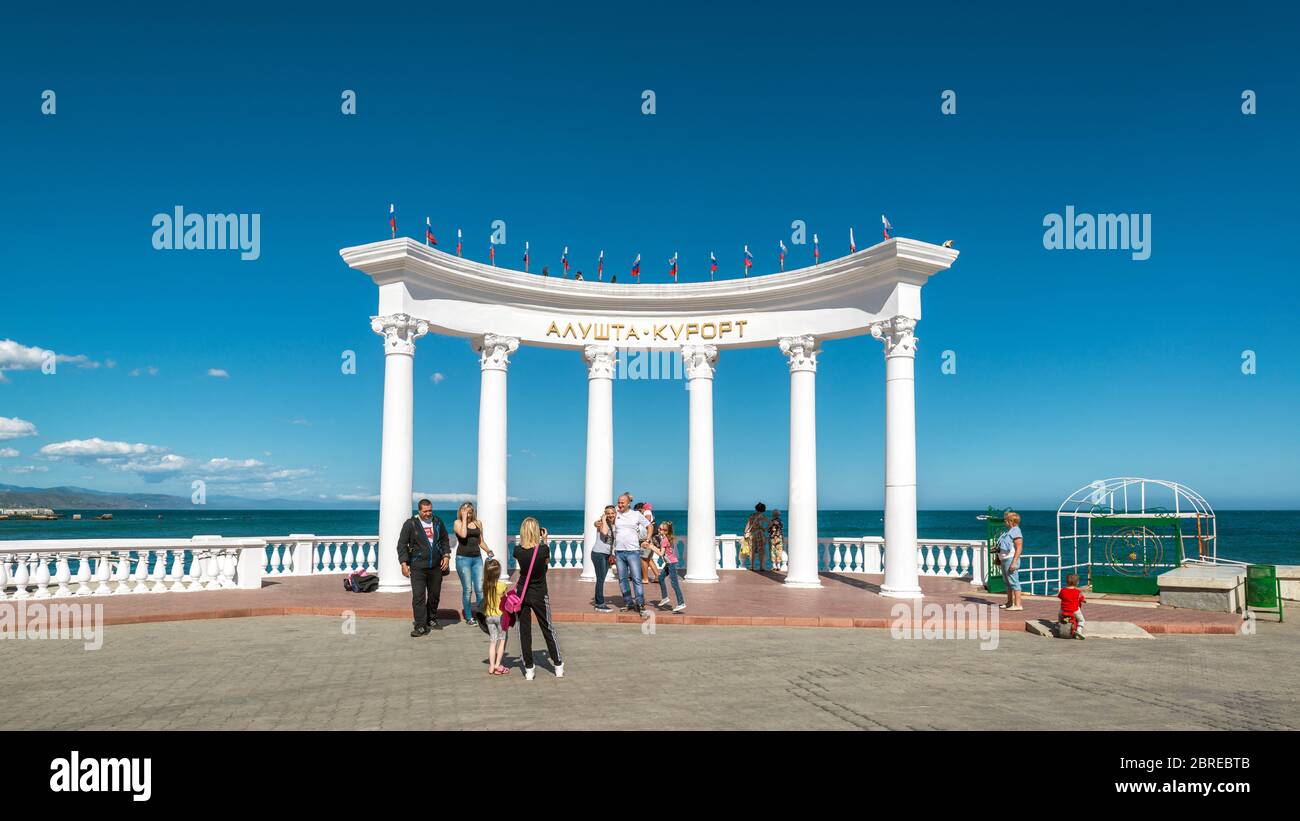 Alushta, Crimea - May 15, 2016: People promenade on the waterfront in Crimea, Russia. The famous rotunda 'Resort Alushta' on the beach. Beautiful pano Stock Photo