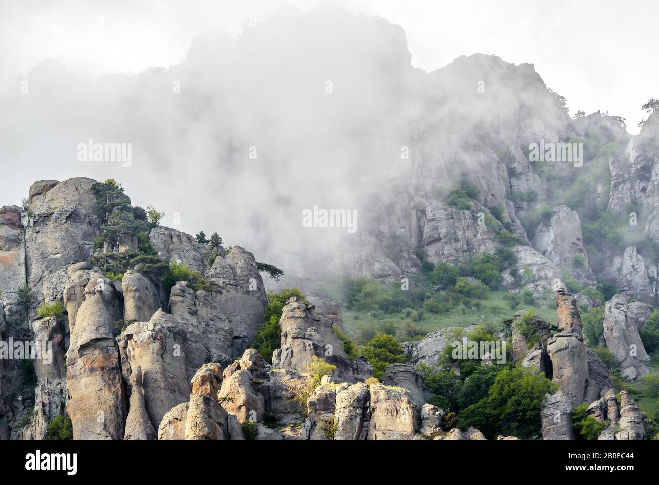 Mountain landscape with fog, Crimea, Russia. Valley of Ghosts of misty Demerdji mountain. This place is a natural tourist attraction of Crimea. Scenic Stock Photo