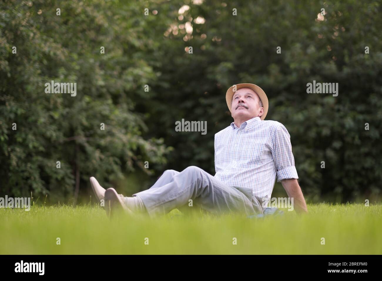 Elderly Spanish Man Resting On Fresh Air Lying On Ground Looking Up Stock Photo Alamy