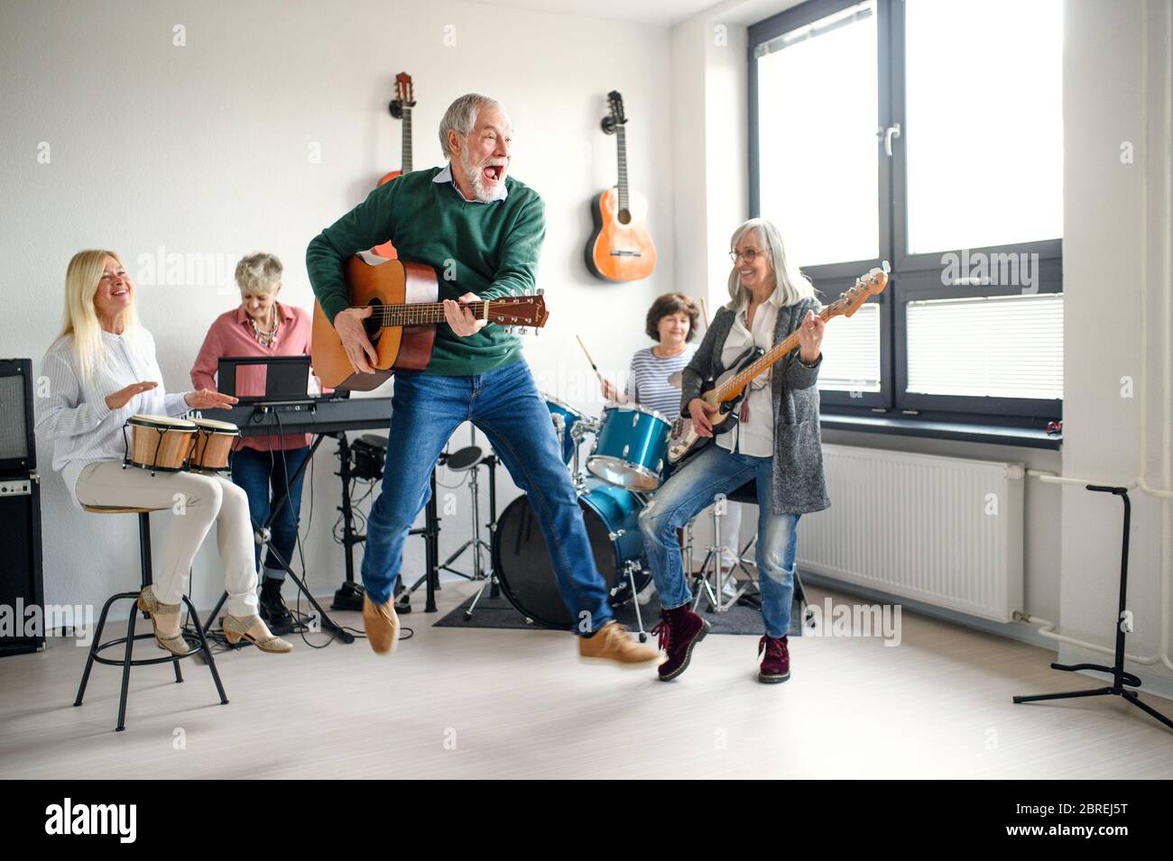 Group of senior people playing musical instruments indoors in band