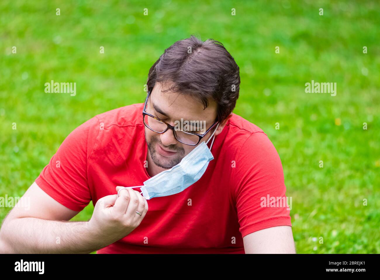 Man wearing surgical mask while he is outside Stock Photo - Alamy