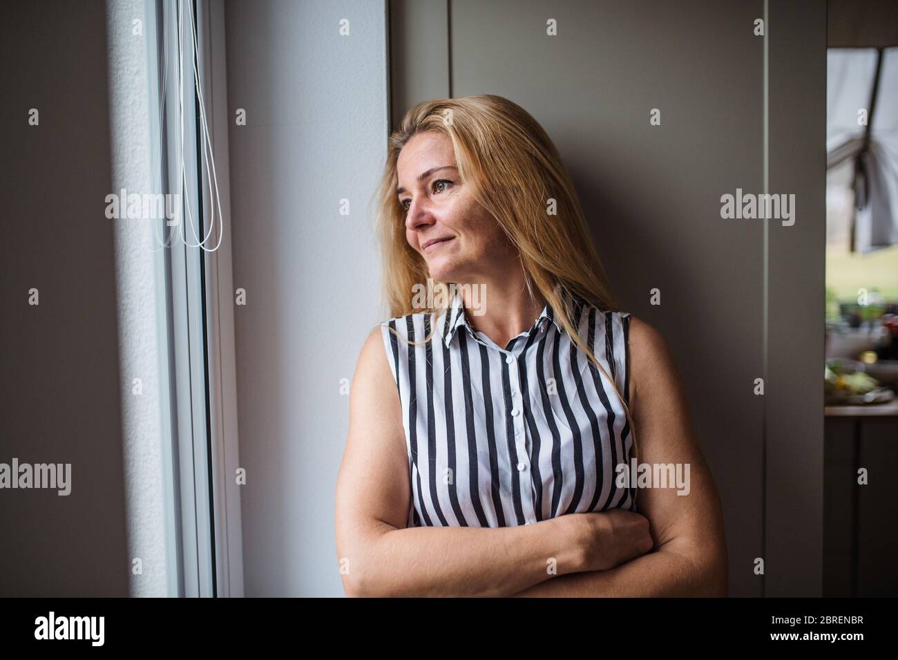 Front view portrait of woman standing indoors at home, resting. Stock Photo