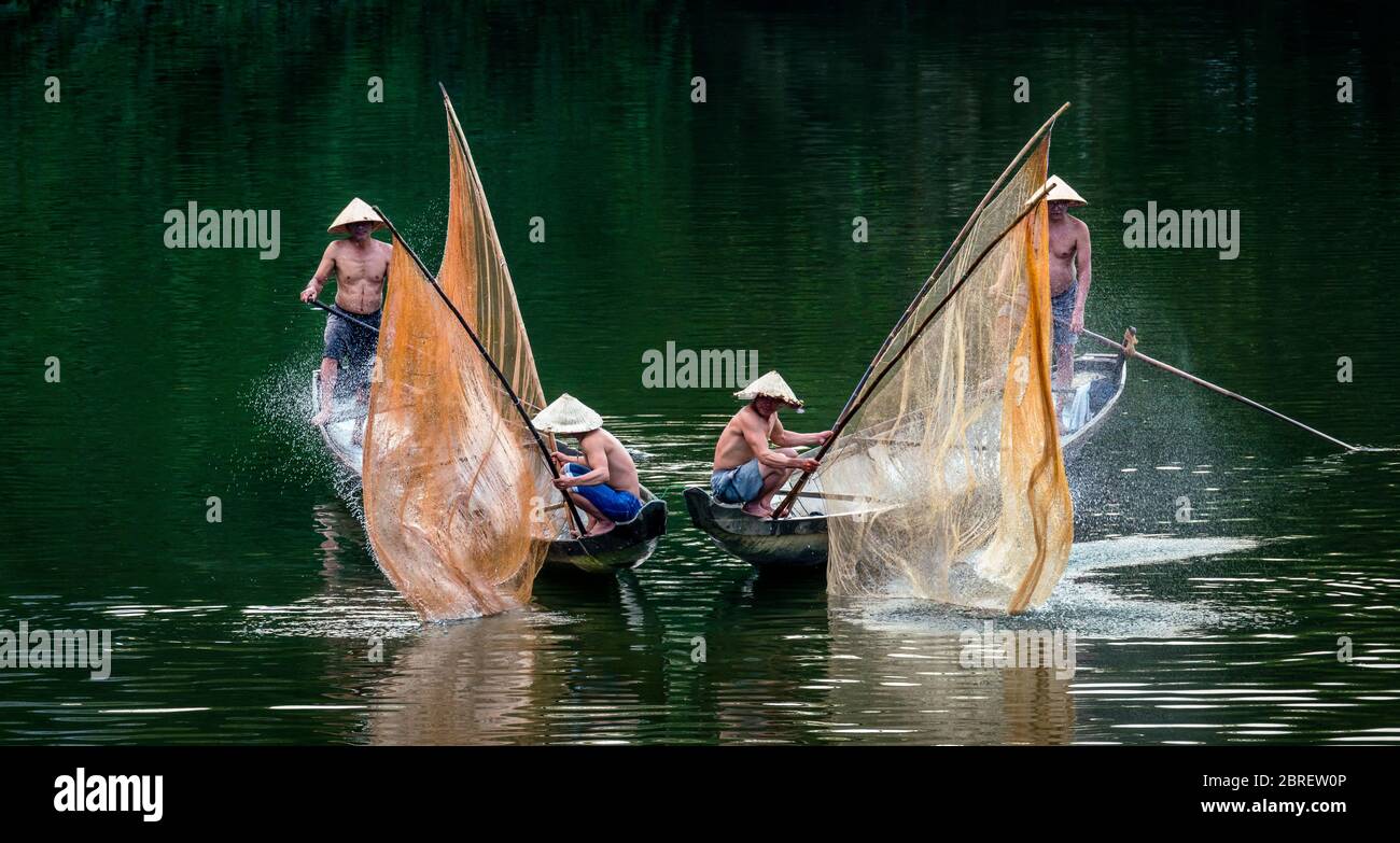 HUE, VIETNAM - MAR 07, 2018: Vietnamese fishermen check the fishnet on two boats from the peaceful Song Nhu Y River on 07 March 2018 in Hue, Vietnam Stock Photo