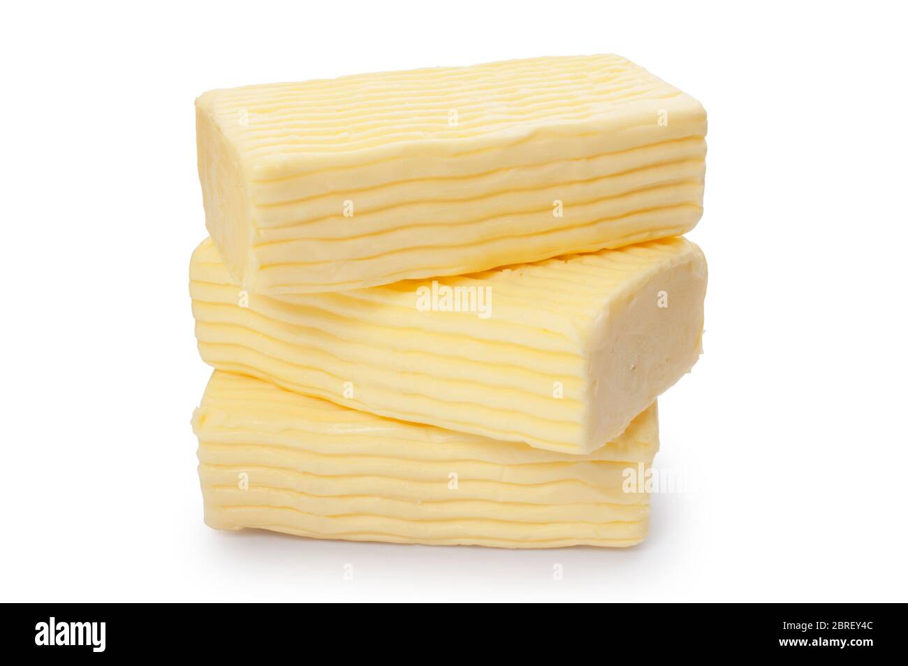 Studio shot of block of rich, creamy butter cut out against a white background - John Gollop Stock Photo