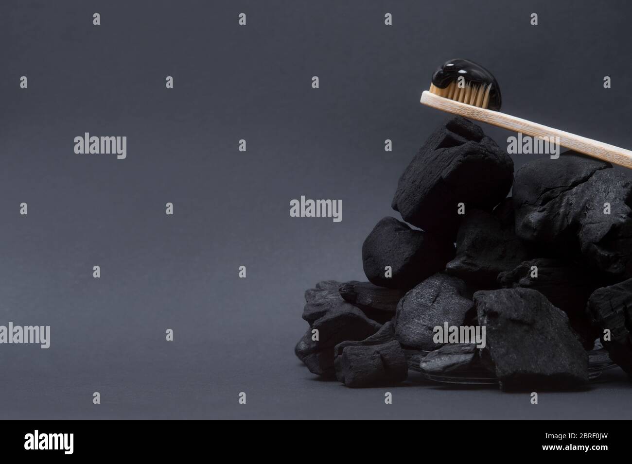 Natural toothpaste activated charcoal and bamboo toothbrush on black background. Zero waste concept. Stock Photo
