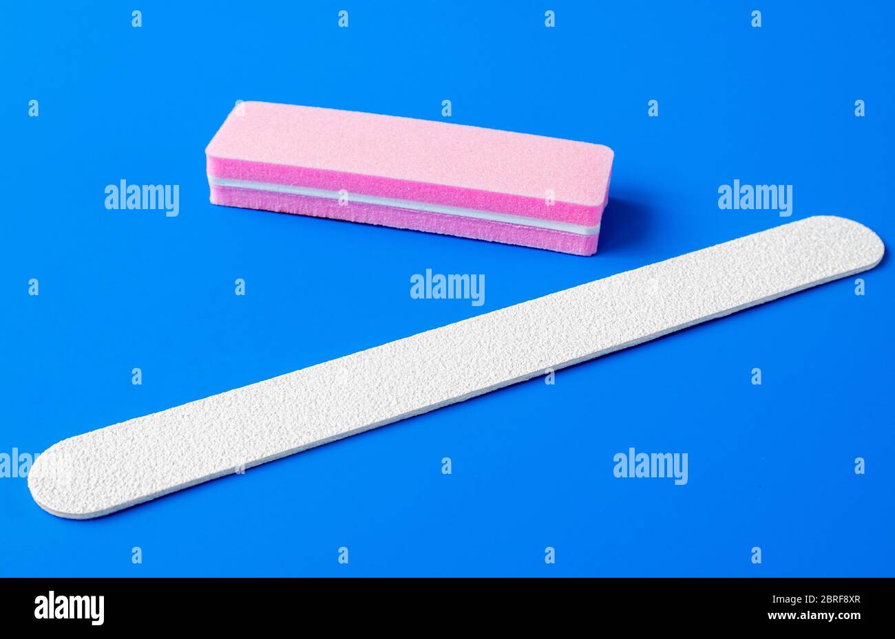 Sanding file sponge for manicure and nailfile on a blue background Stock Photo