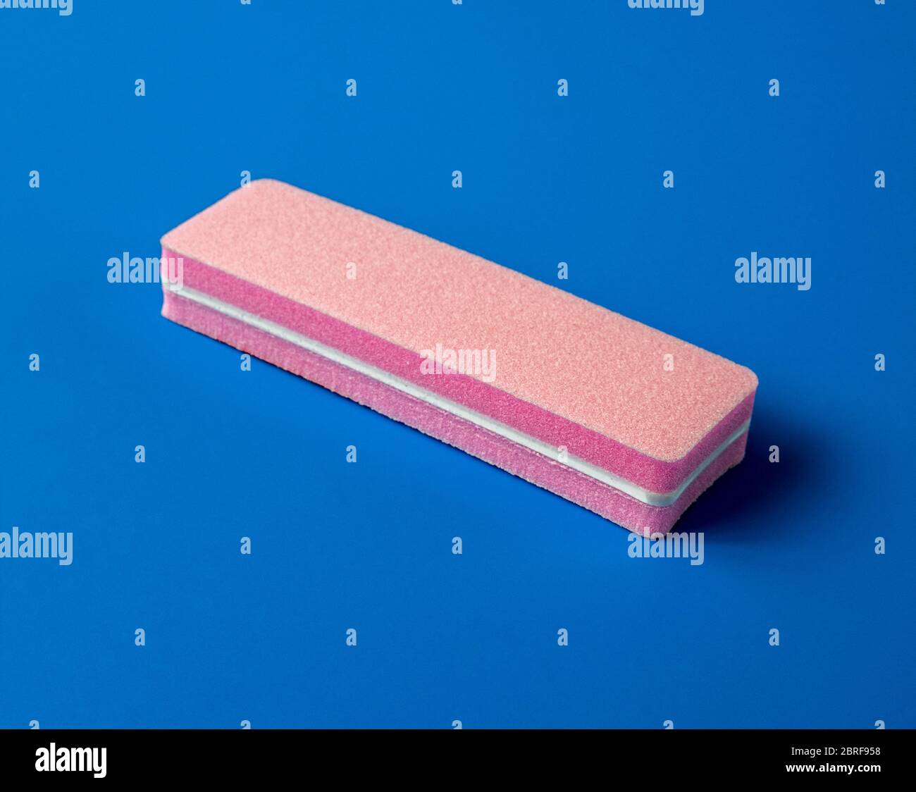 Sanding file sponge for manicure on a blue background Stock Photo
