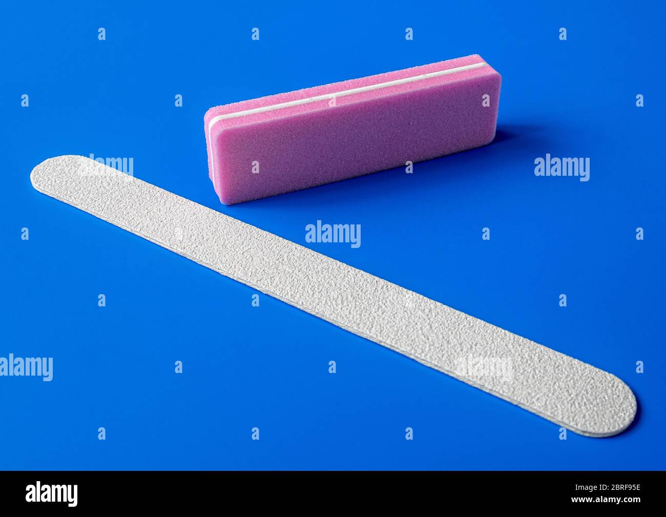 Sanding file sponge for manicure and nailfile on a blue background Stock Photo