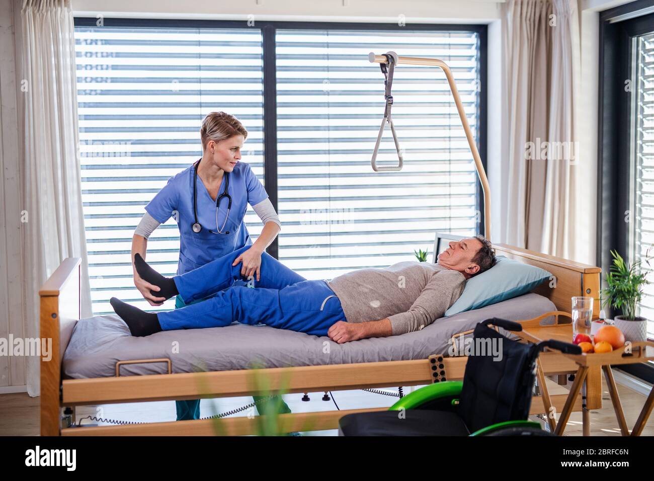 A healthcare worker and senior patient in hospital, physiotherapy. Stock Photo