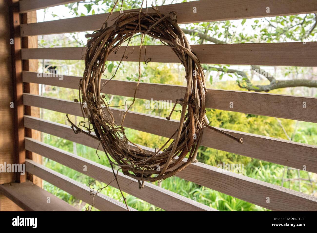 Grapevine wreath on wood background. Handmade Eco Decoration. Stock Photo