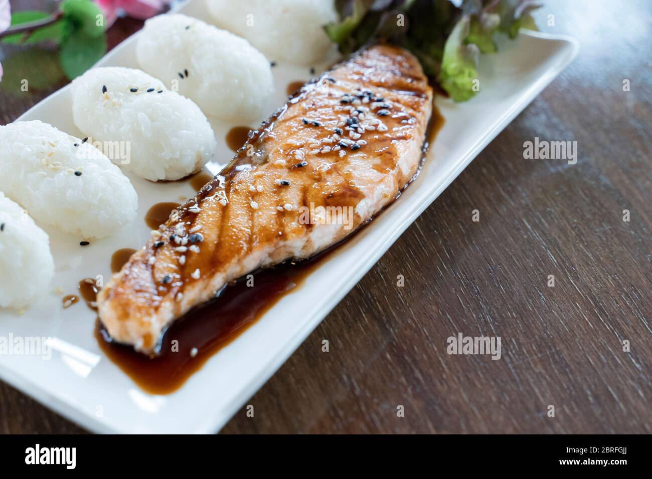 Salmon fillet topped with tare sauce and rice. Stock Photo
