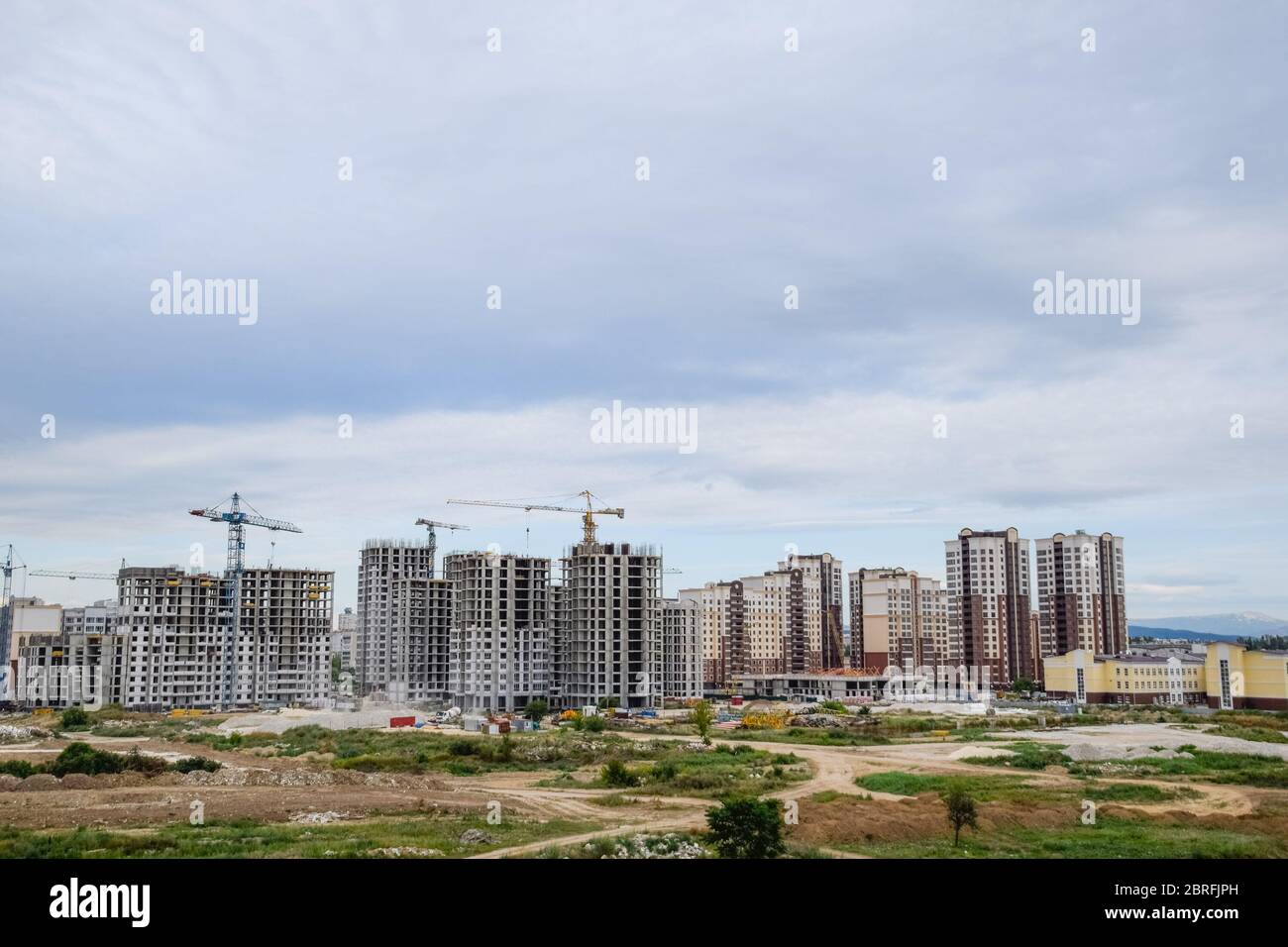 The construction of multi-storey residential buildings. Tower cranes at a construction site. Stock Photo