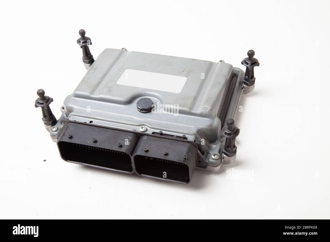 A plastic car engine control unit with metal elements on a white isolated background is the back center of the various subsystems, components and asse Stock Photo